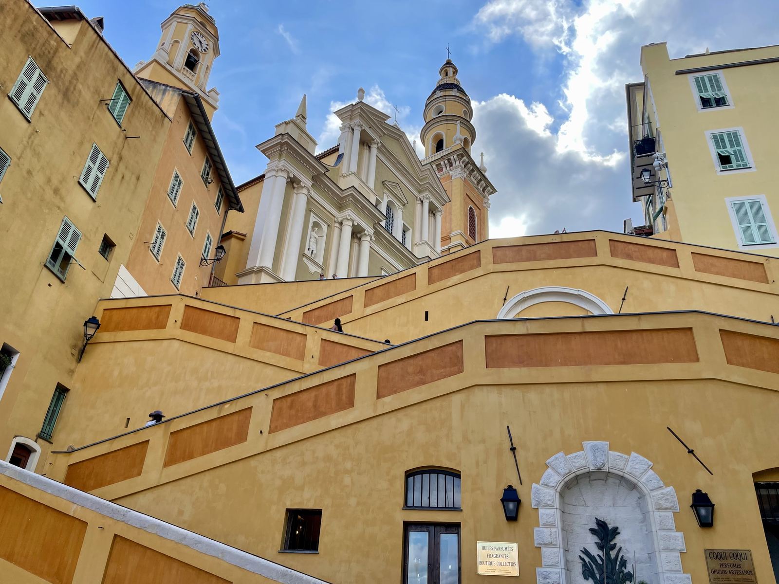 Menton's baroque church of Saint-Michel — yellow and white facade, grand staircase, dramatic sky